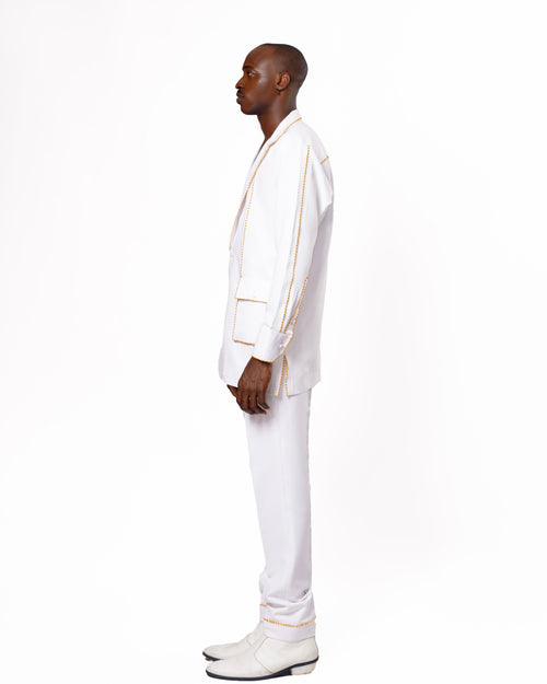 A contemporary suit design featuring a deep V-neck blazer, complemented by matching tailored pants and white shoes. Ideal for high-fashion and modern style themes.