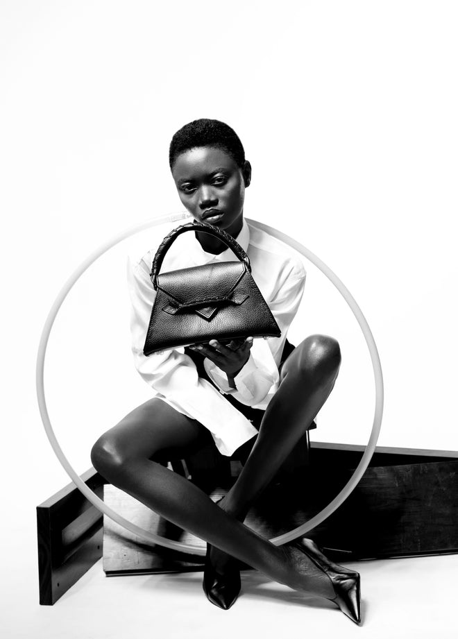 alt="A model showcasing a Chic Ese Micro Top Handle Bag in a sleek design, featuring a structured silhouette and elegant handle, perfect for stylish outings, available at Pink Maison"