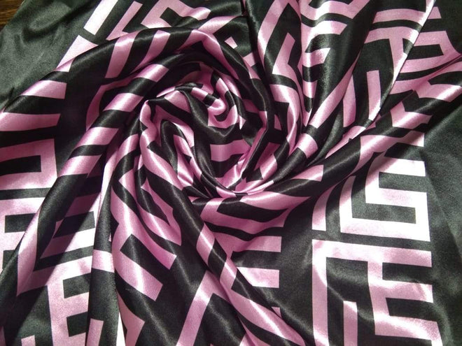 Alt="Luxurious Pink Maison Logo Monogram Scarf in black, featuring an elegant pink and black geometric pattern on elegant silky fabric, which is intricately arranged to showcase the bold and stylish design."